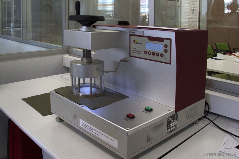 Установка имитирует давление водяного столба на ткань. Фиксируется то значение «высоты водного столба», при котором на поверхности образца появятся три капли воды Установка имитирует давление водяного столба на ткань. Фиксируется то значение «высоты водного столба», при котором на поверхности образца появятся три капли воды